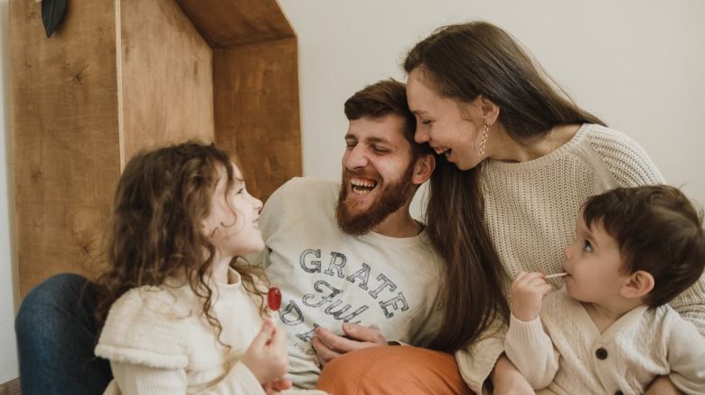 Happy family enjoying quality time with their children indoors, sharing laughter and joy.